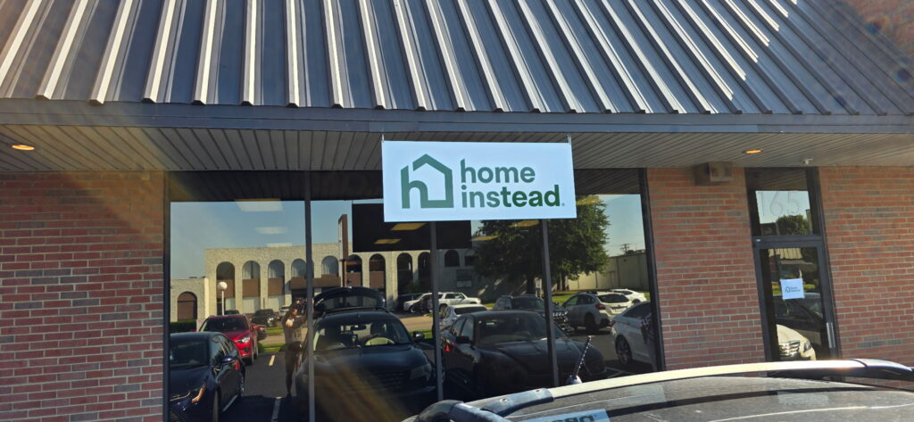 Custom hanging storefront sign for Home Instead installed by The Sign Shop in Lexington, Kentucky.
