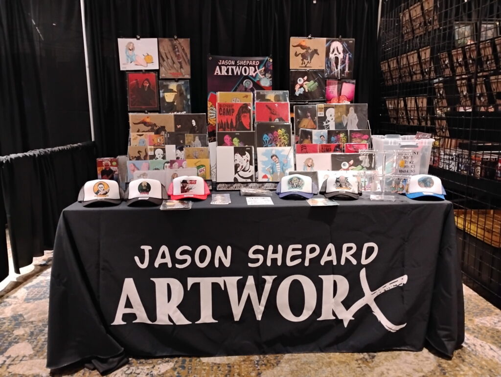 Custom trade show booth display featuring branded table cover, promotional signage, artwork prints, and display graphics by The Sign Shop in Lexington, Kentucky.