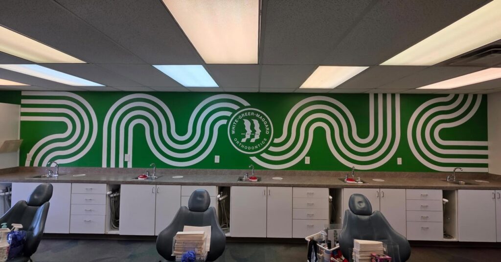 Large green and white custom wall graphic installed in orthodontic treatment area