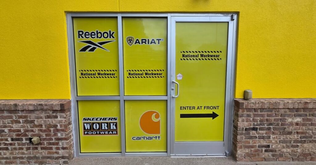 Full storefront window graphics with National Workwear branding and workwear company logos in Lexington, KY.
